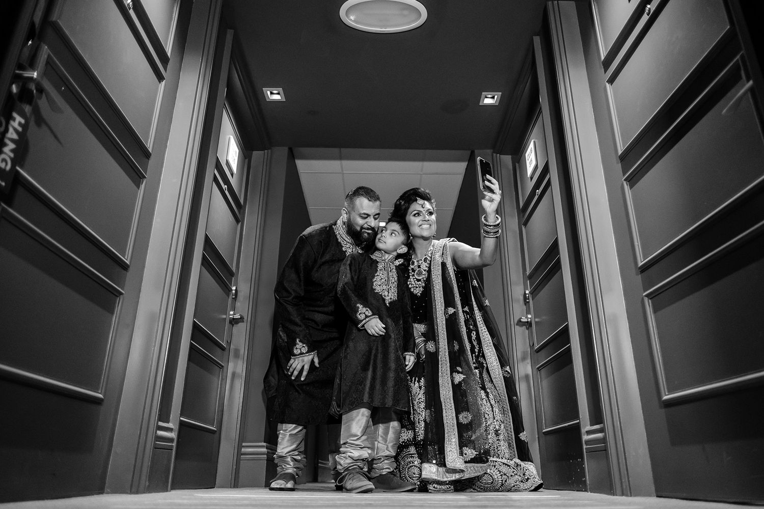 Dramatic low-angle black and white shot of people in a modern hallway.