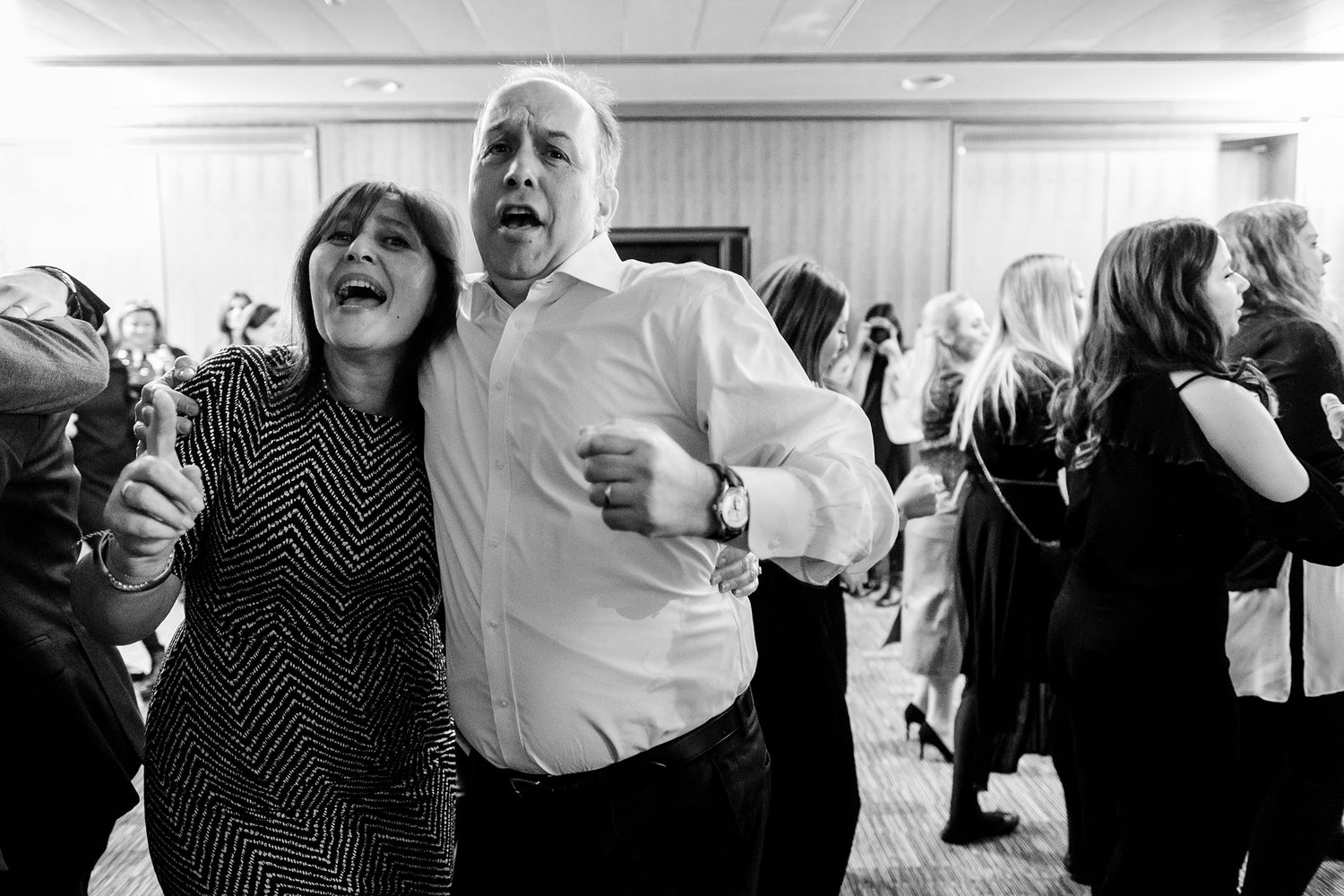 Black and white candid shots of party guests dancing and celebrating with enthusiasm.