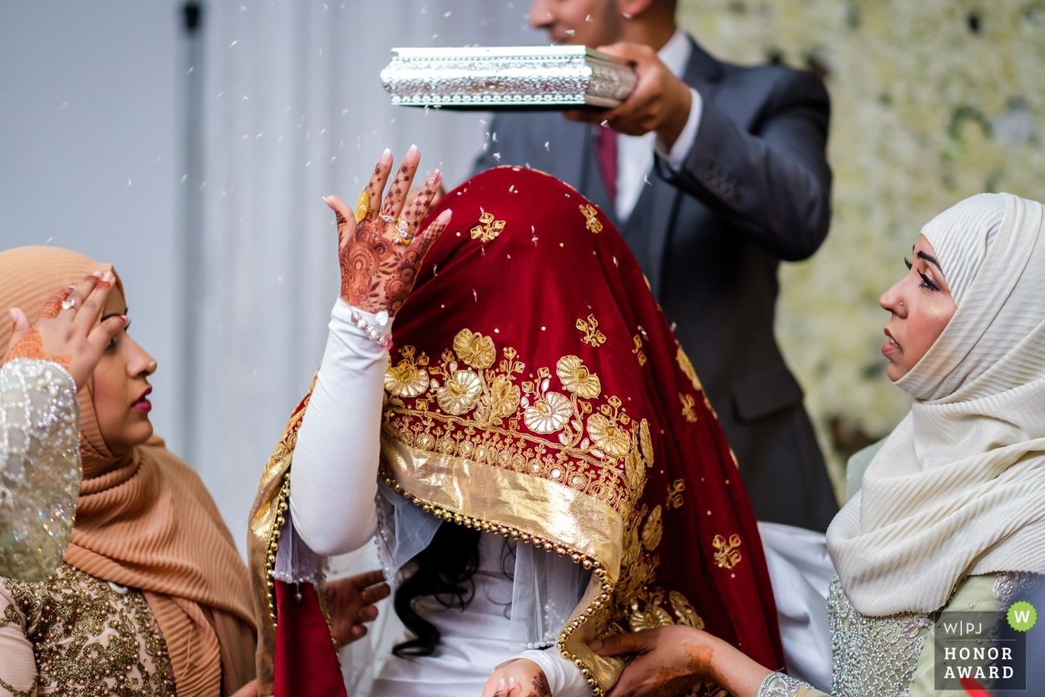 Traditional Indian wedding ceremony with guests gathered around a couple during rituals and customs.