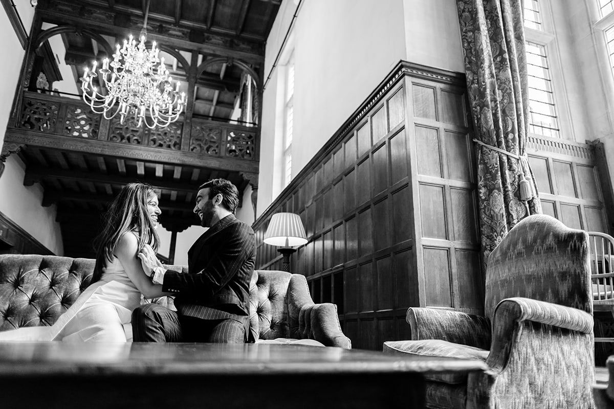 Dramatic black and white wedding photography in historic building with large windows.