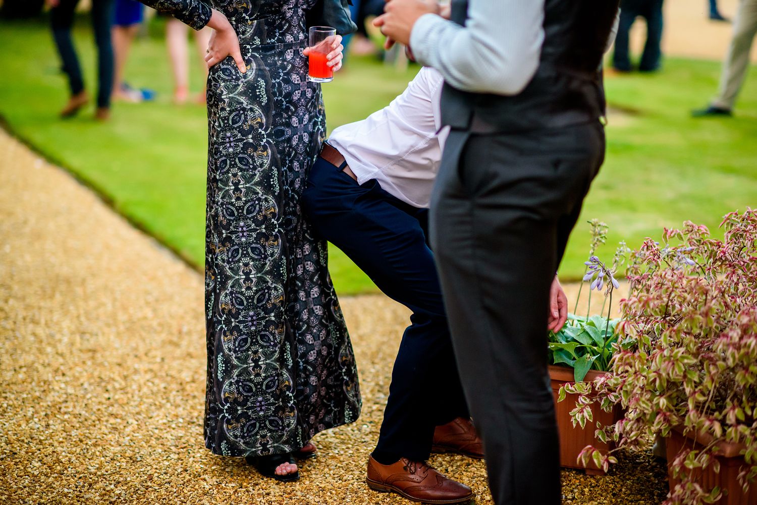 Wedding guests dancing and celebrating on an outdoor patio or garden space.