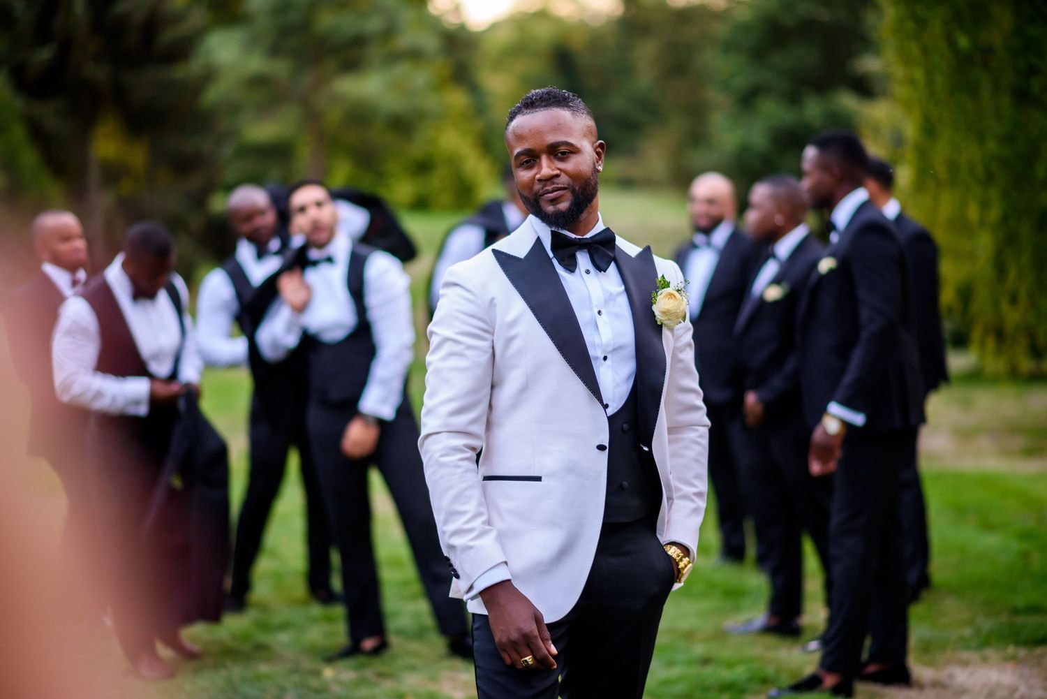 Wedding party in formal attire posing and celebrating outdoors.
