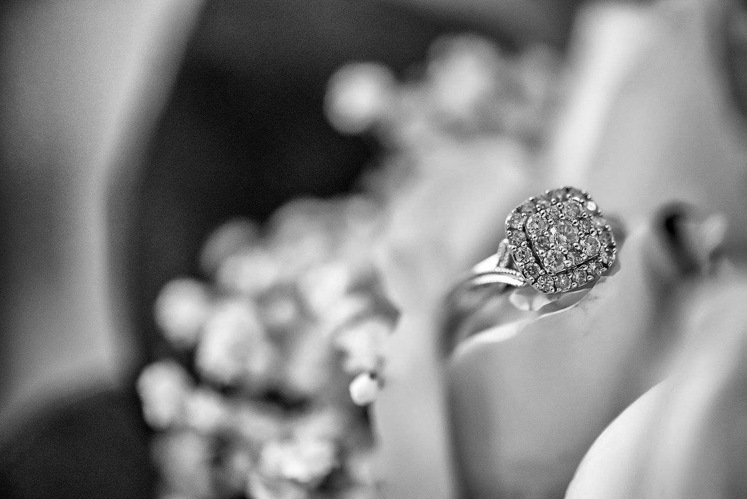 Sparkling diamond engagement ring and wedding bands photographed in macro detail.