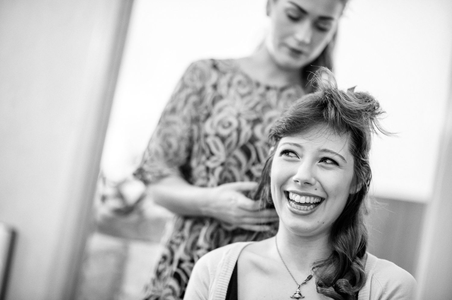 Black and white candid of people laughing together in an intimate setting.