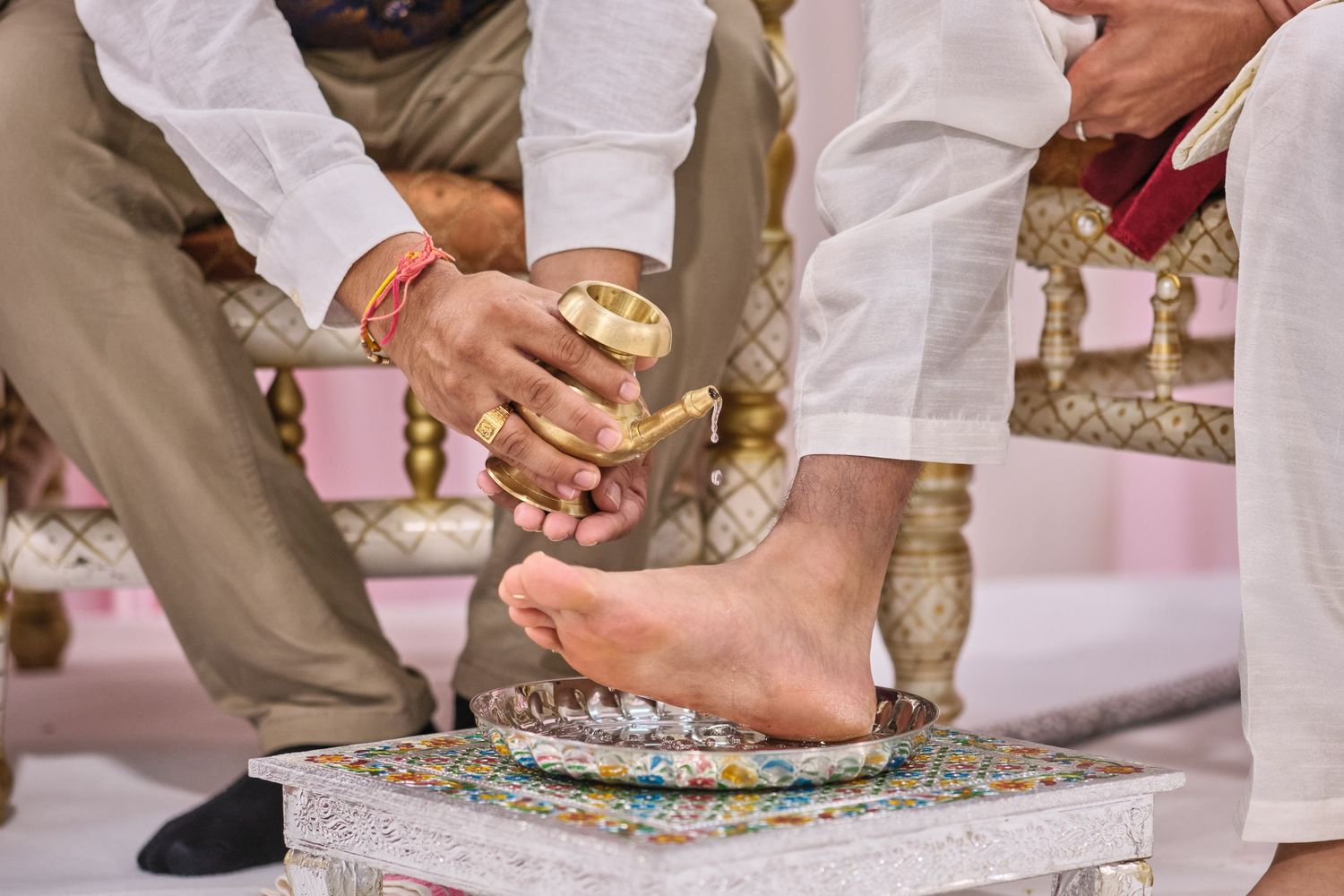 Traditional Indian wedding ritual showing feet and hands during a sacred ceremony.