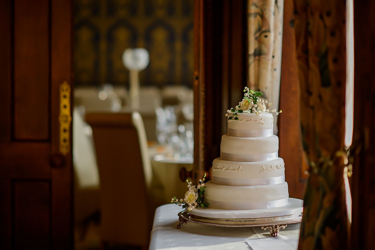 Elegant white wedding cake displayed with candles and traditional decor.