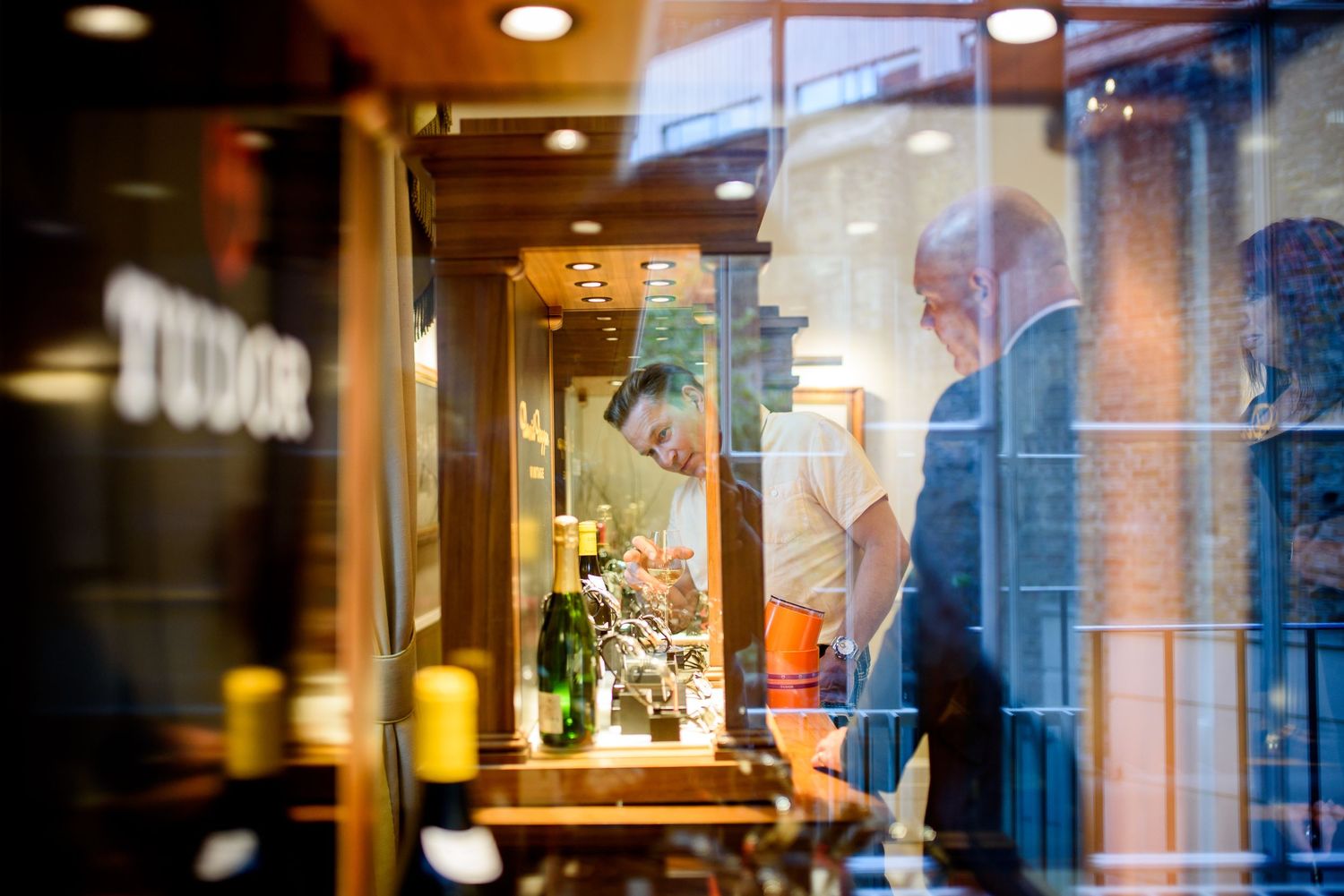 Modern restaurant interior with glass walls and warm lighting creates an inviting dining atmosphere at night.