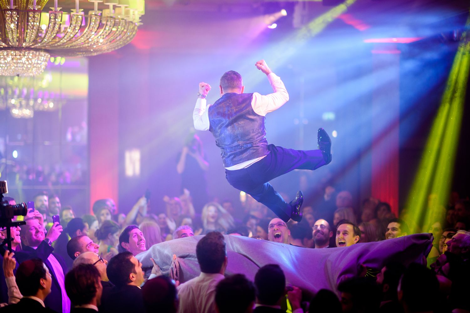 Energetic dance party scene with colorful lighting effects and crowded dance floor.