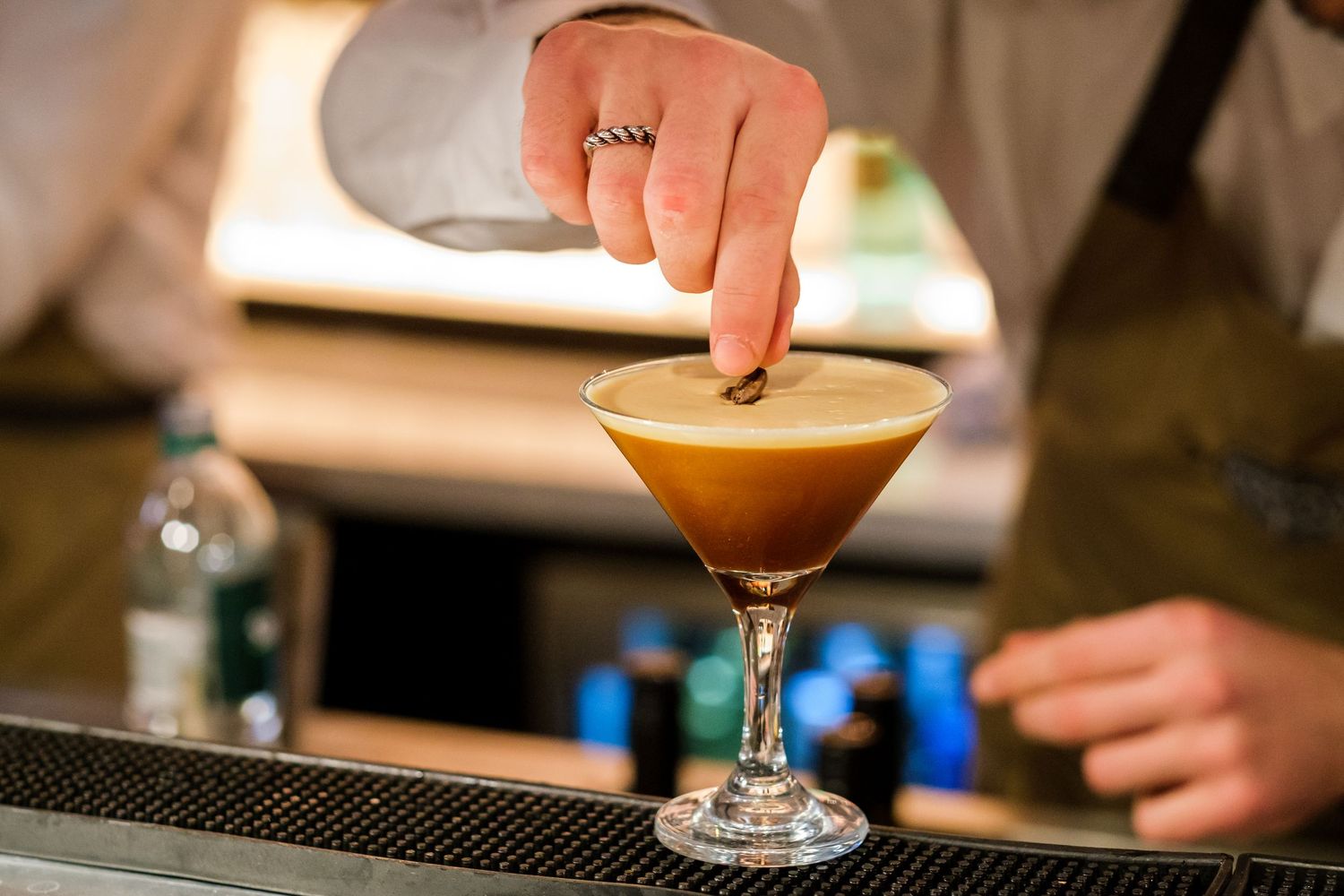 Colorful cocktails being served at a restaurant bar counter.