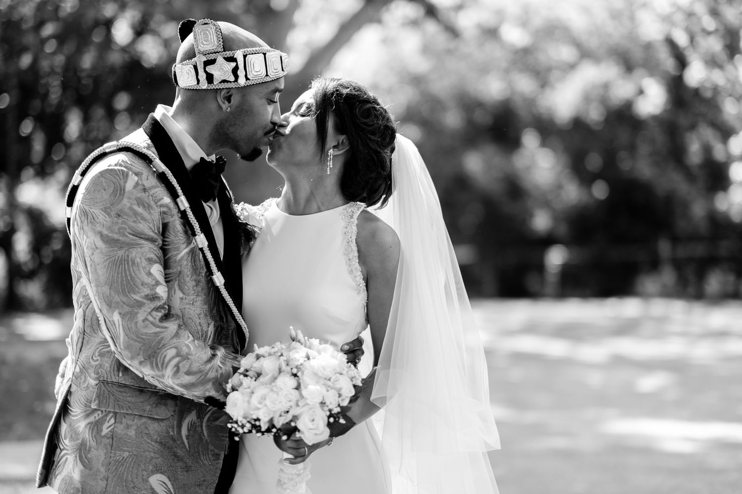Black and white photo of a joyful wedding celebration outdoors.
