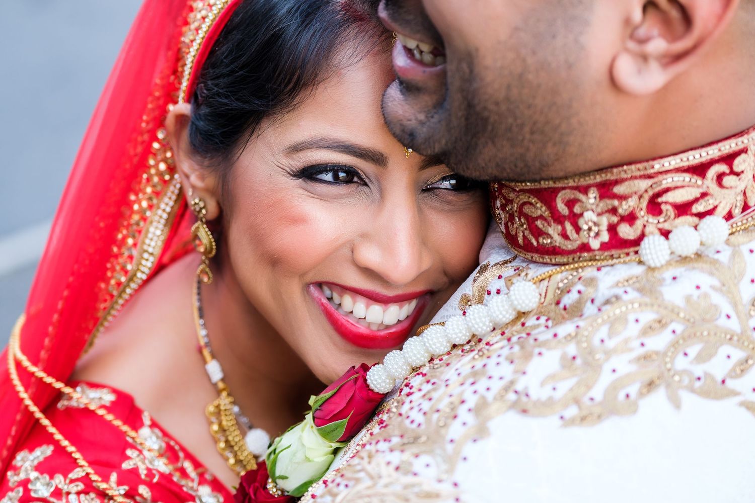 Close-up shots of couple in traditional red and white Indian wedding attire.