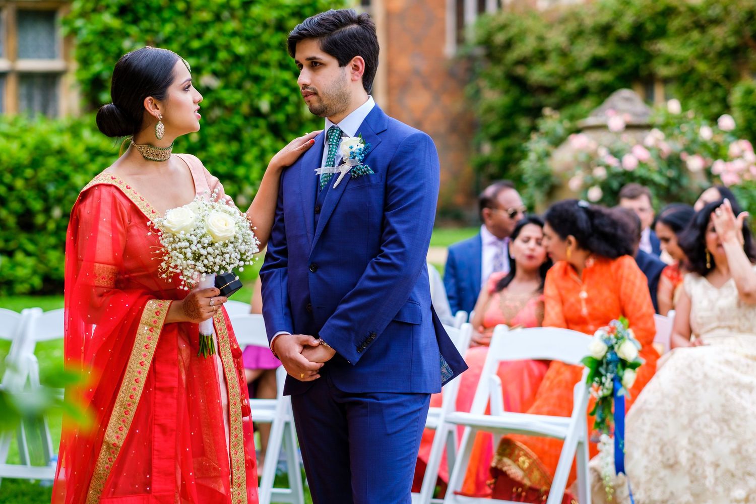 A couple in traditional Indian and Western attire dancing together at an outdoor wedding celebration.