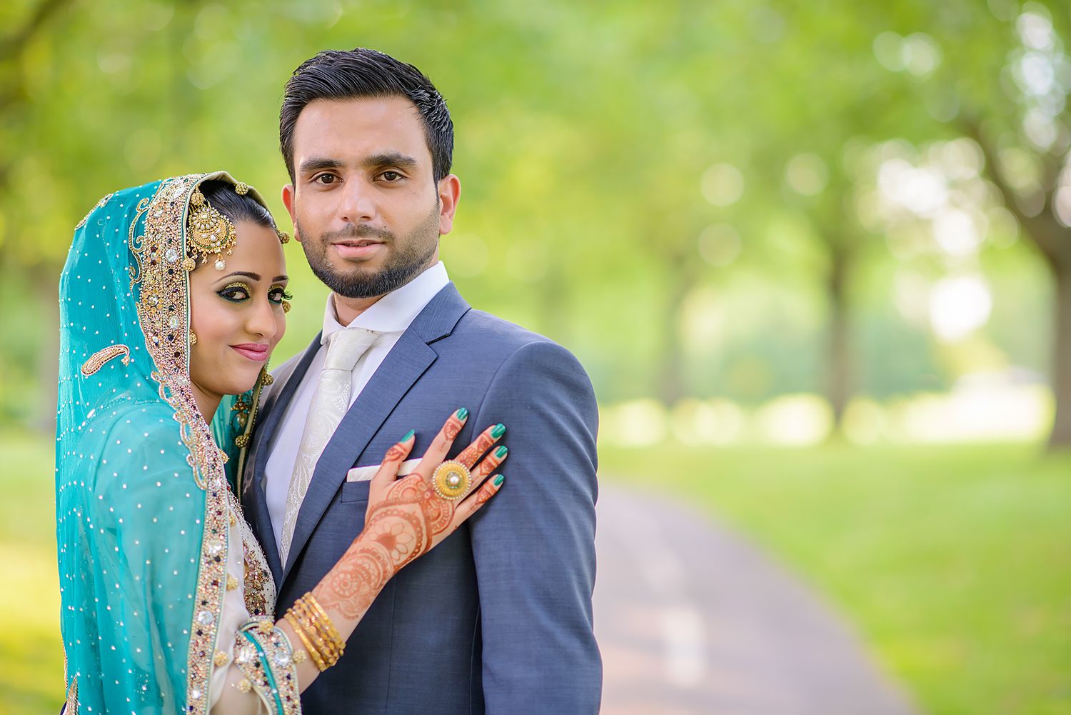 Outdoor wedding photography in lush green park setting with traditional South Asian attire.