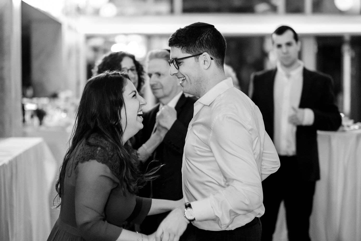 Happy couples sharing dances at an indoor celebration event.