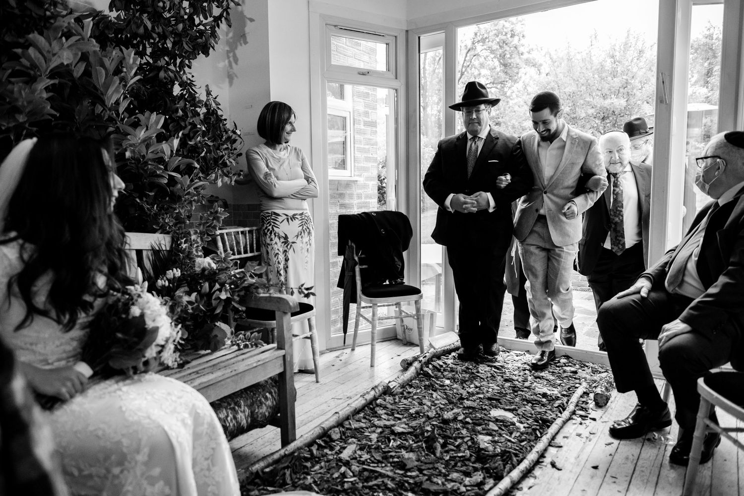A series of black and white wedding photographs showing candid moments between people on a porch.