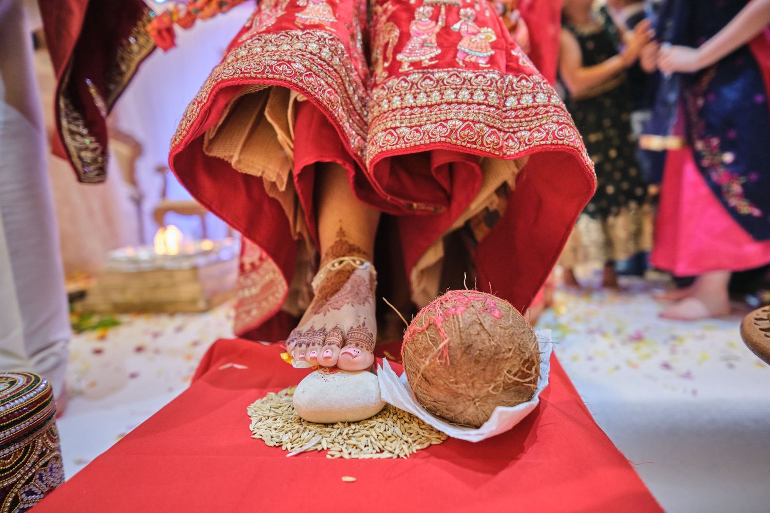 A collection of traditional Indian wedding jewelry and accessories displayed on a red surface.