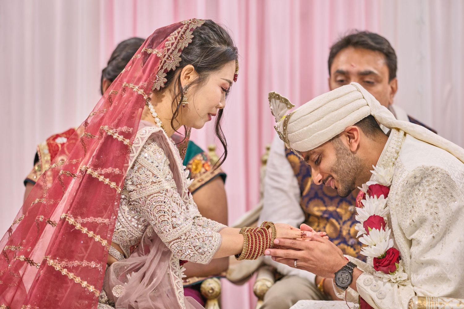 Traditional Indian wedding ceremony with couple exchanging rings during marriage ritual.