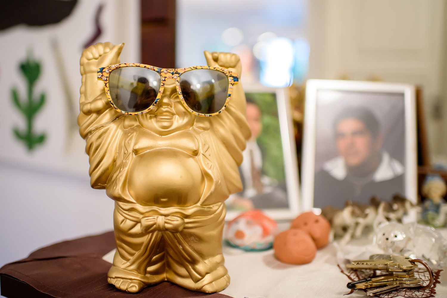 A decorative golden Buddha figure wearing sunglasses sits on display at a wedding reception.