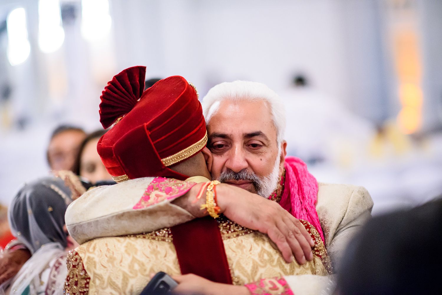 Wedding reception showing guests embracing during emotional celebration moment.
