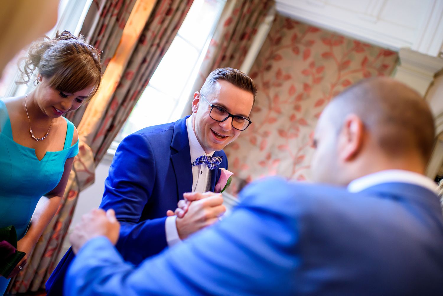 Candid moments shared between wedding guests in a classically decorated venue.
