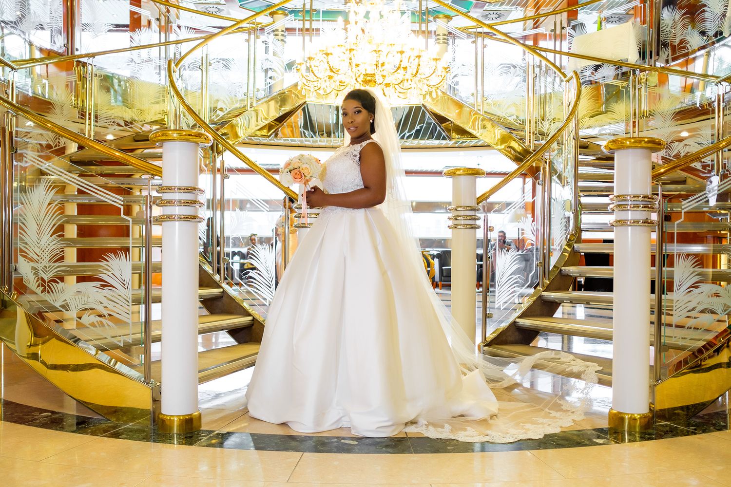 Bride in white ball gown poses in elegant gold and white carousel setting.