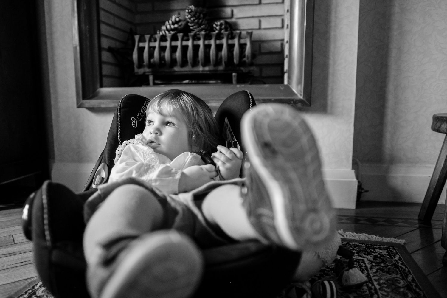Black and white portrait of children playing and laughing while lying down indoors.