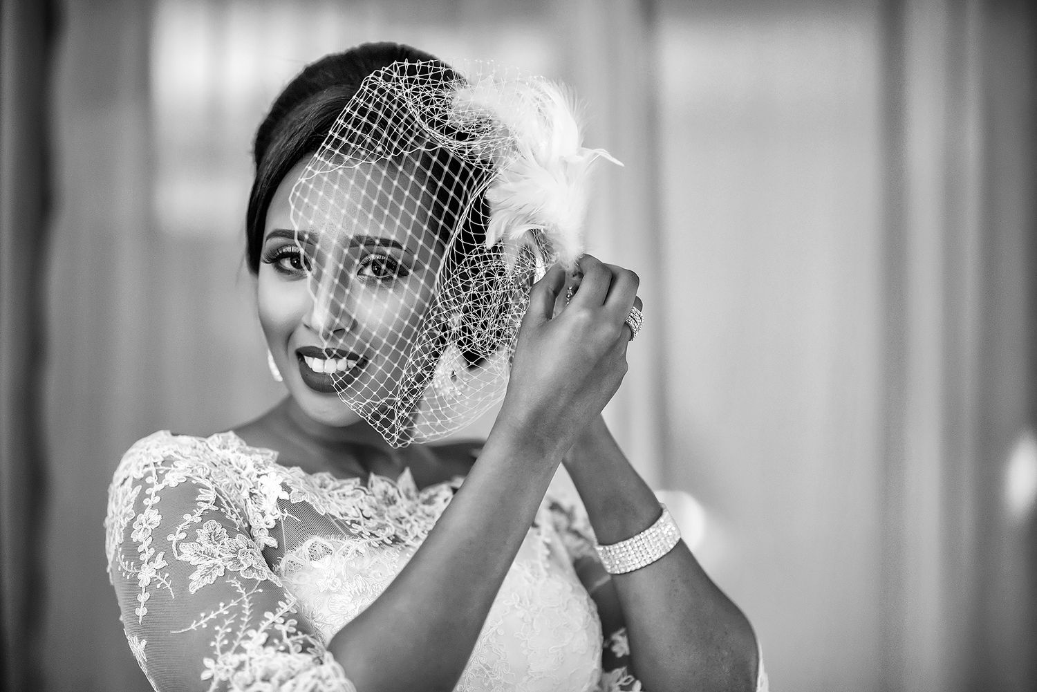 Classic black and white bridal portrait showcases delicate lace veil details.