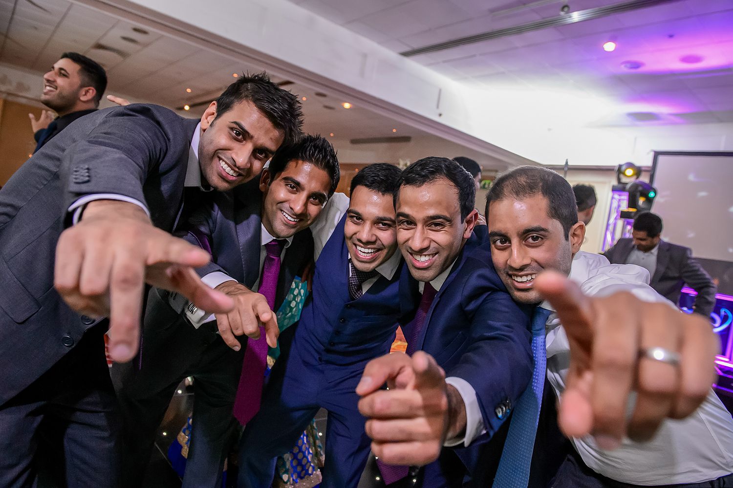 Group of friends laughing and posing together at a festive indoor celebration.