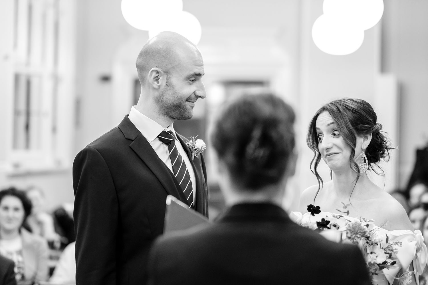 Monochrome wedding reception photos showing candid moments between guests.