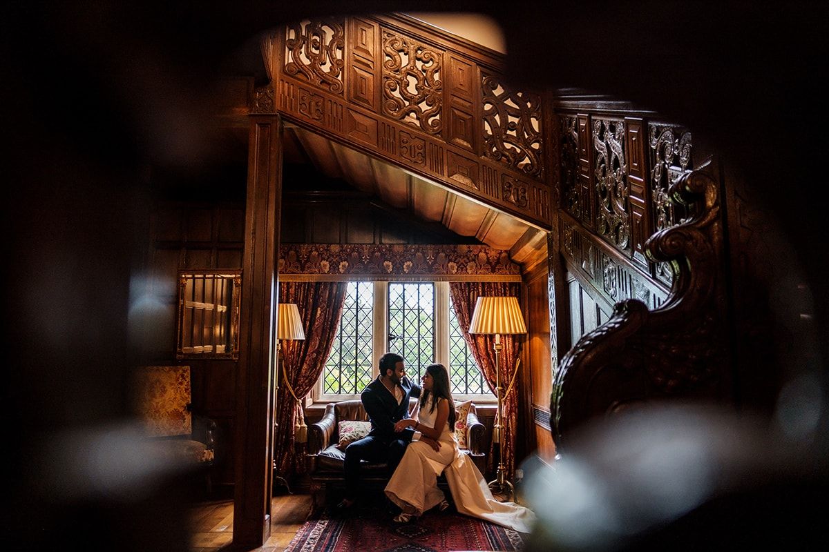 Moody wedding photography with dramatic lighting in ornate wooden interior.