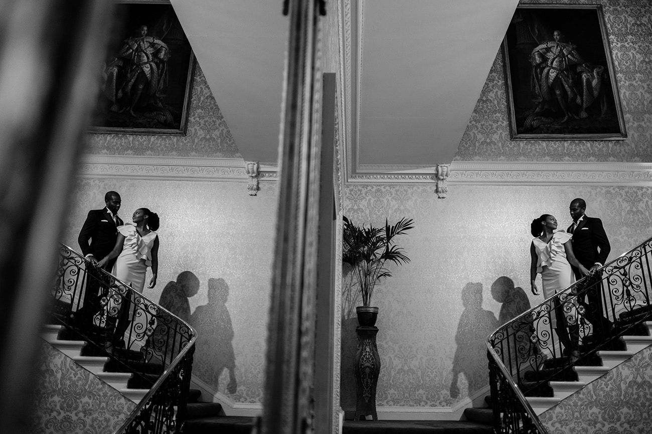 Silhouettes on a grand staircase captured in dramatic black and white photography.