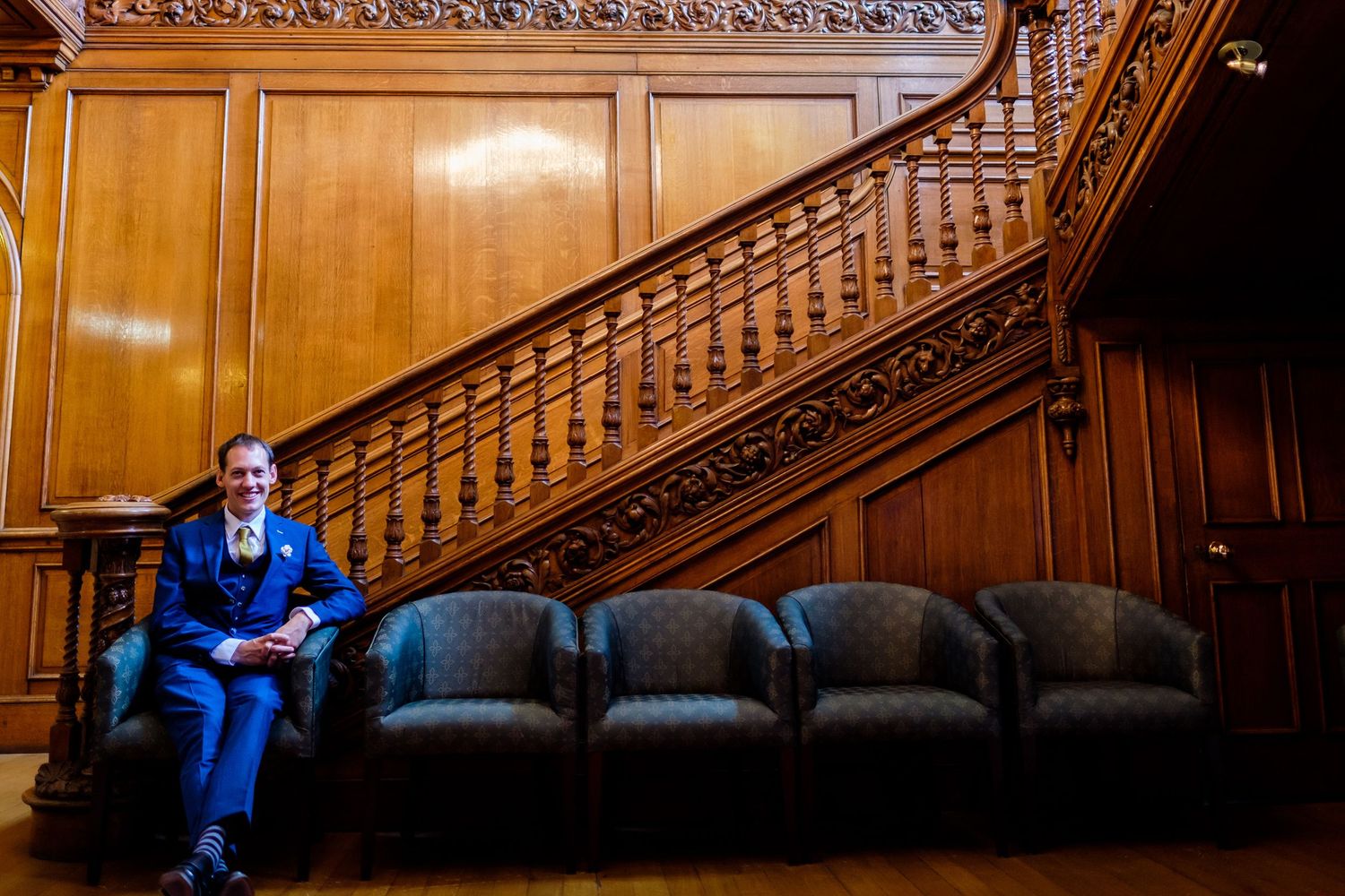 Grand wooden staircase with ornate carvings in an elegant interior setting.