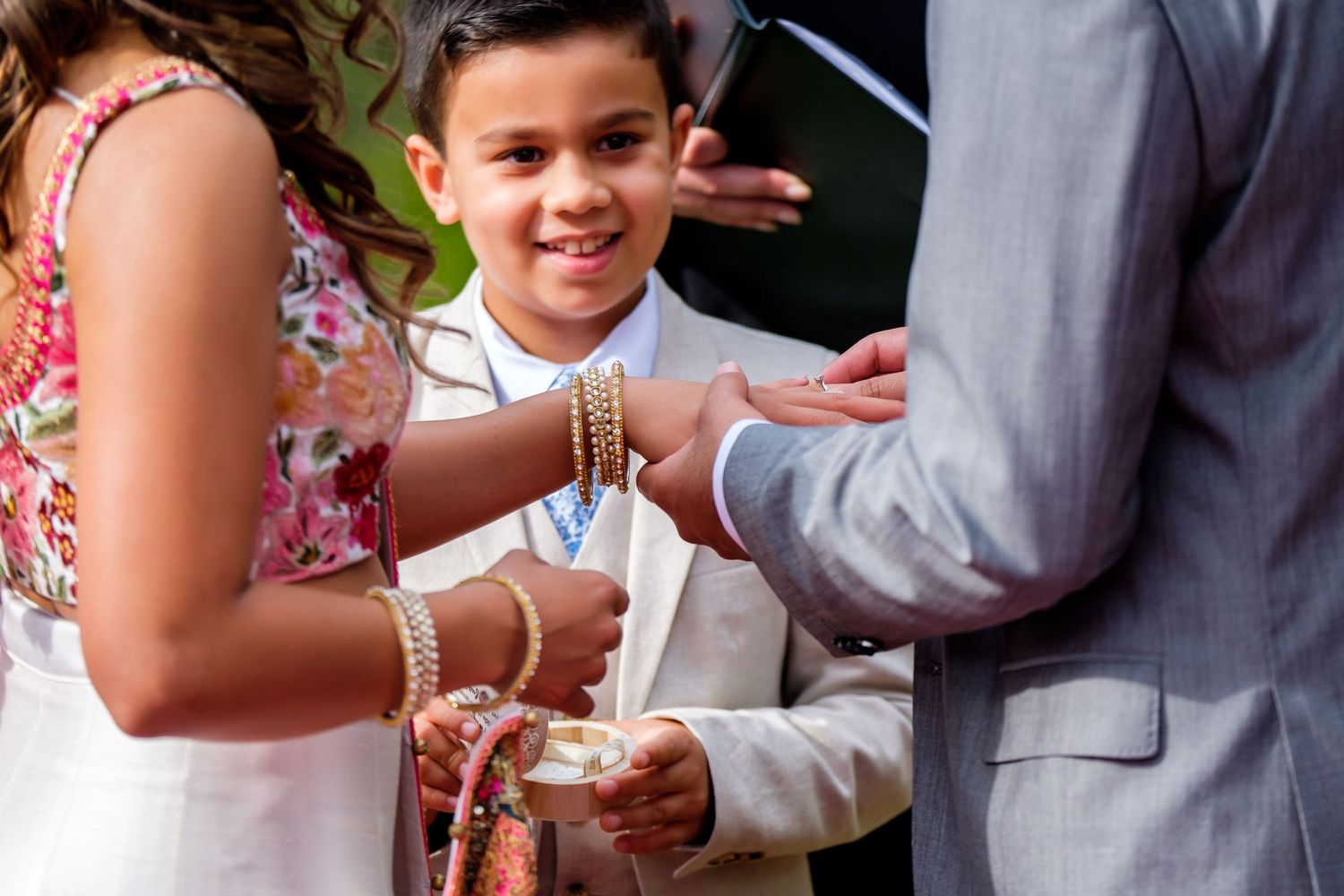 Close-up details of wedding rings and hands during an exchange ceremony.