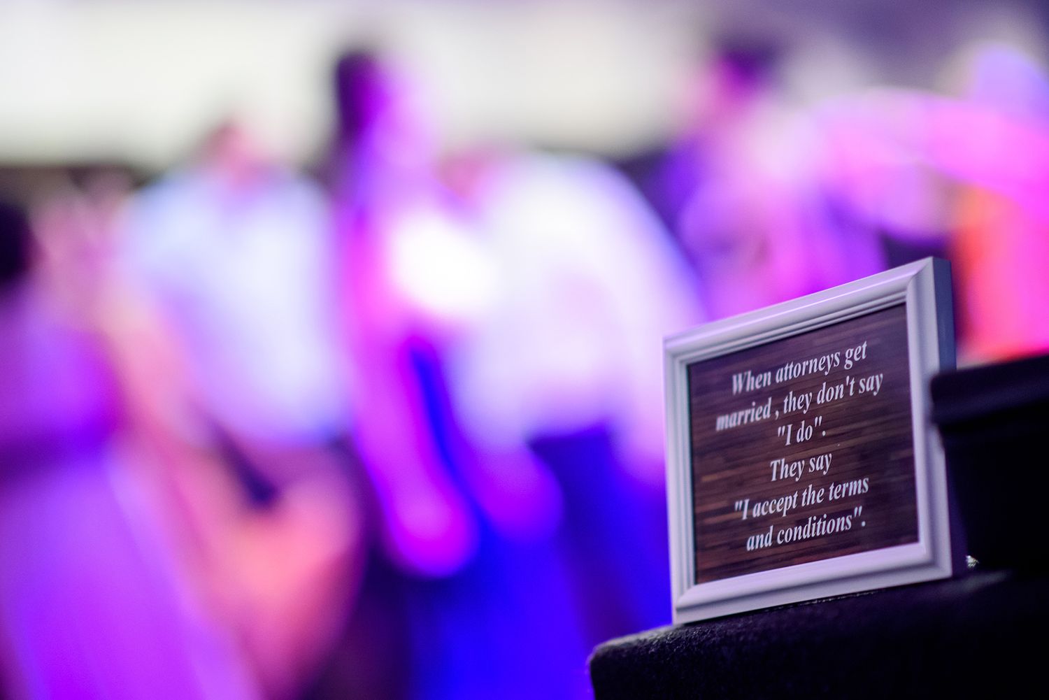 Purple and pink bokeh lights create an abstract background at an event.