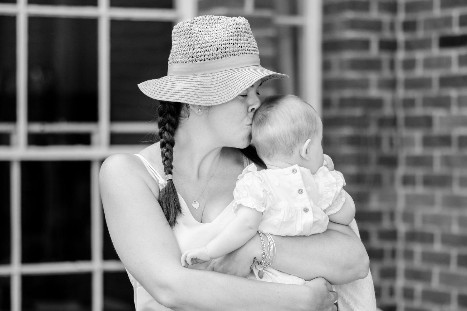 A couple embraces during an intimate wedding moment in front of a brick building.