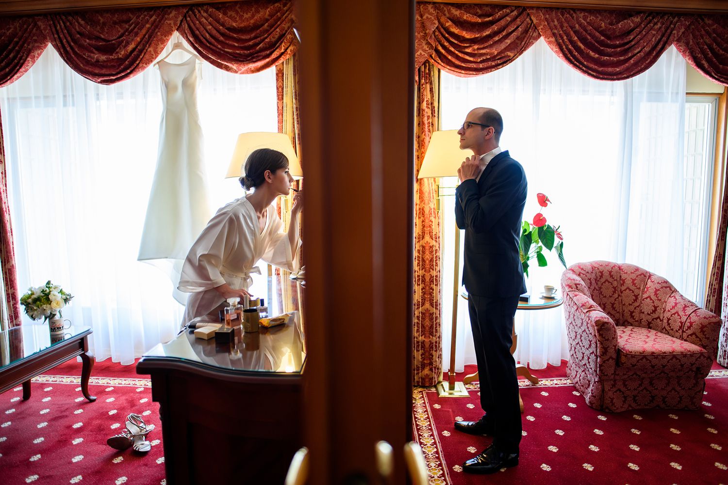 Wedding venue interior featuring elegant red drapes and window lighting.
