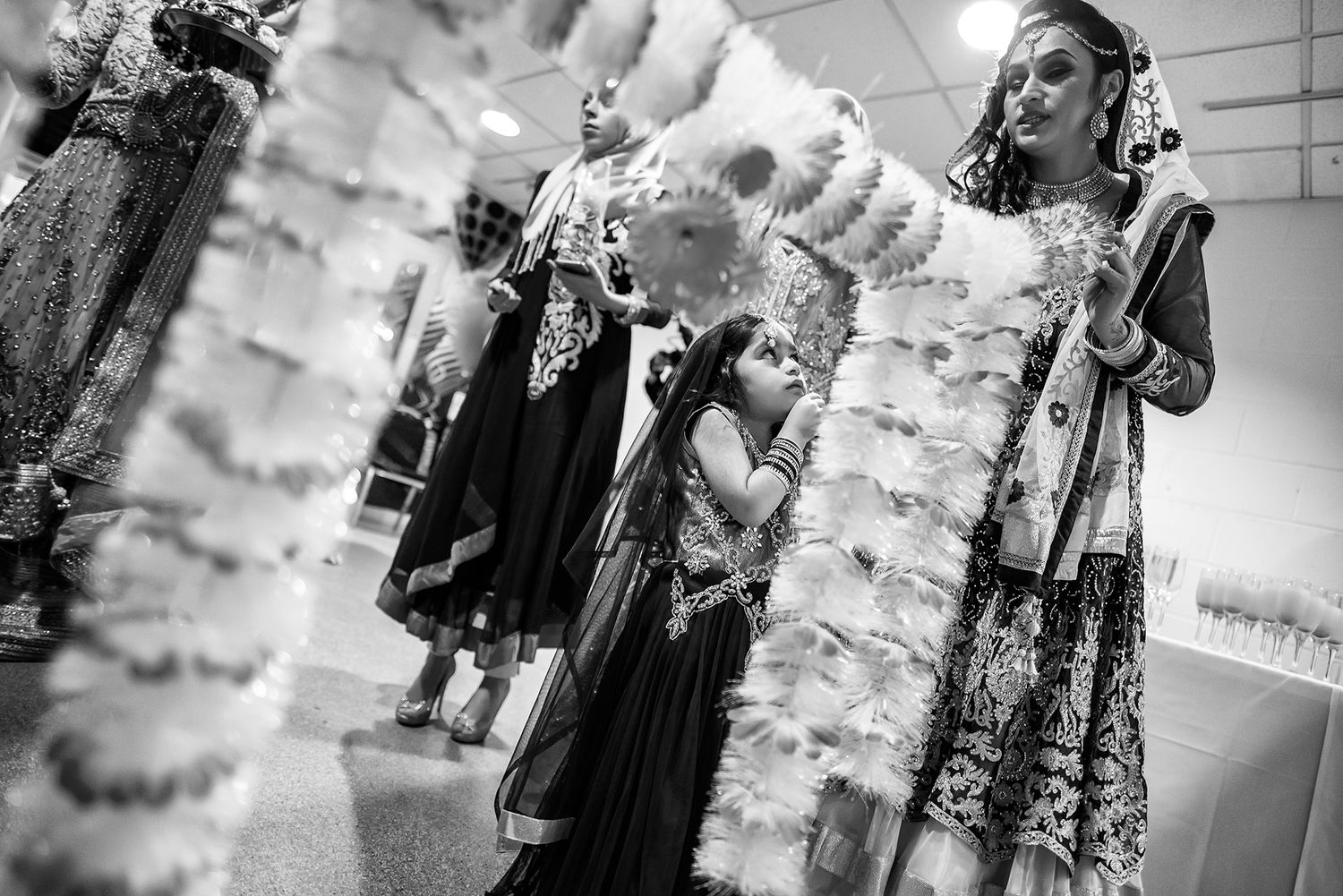 A black and white image of decorative wedding dresses hanging on display.