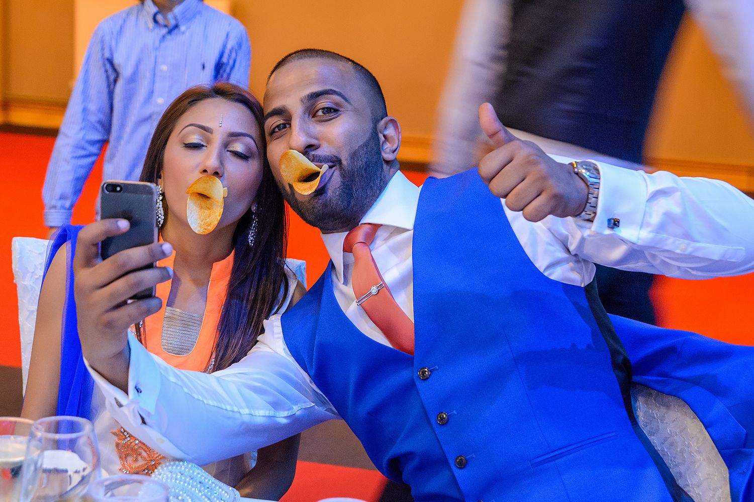 Wedding celebration with vibrant orange and blue color scheme during reception.