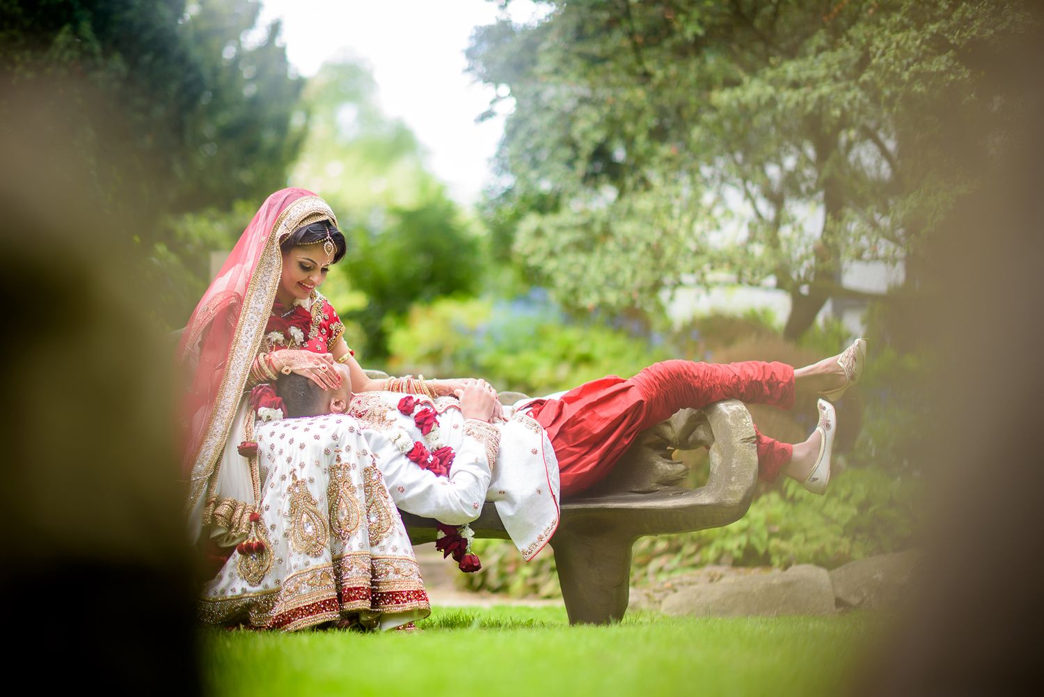 Artistic wedding photography in natural garden setting with soft focus effects.