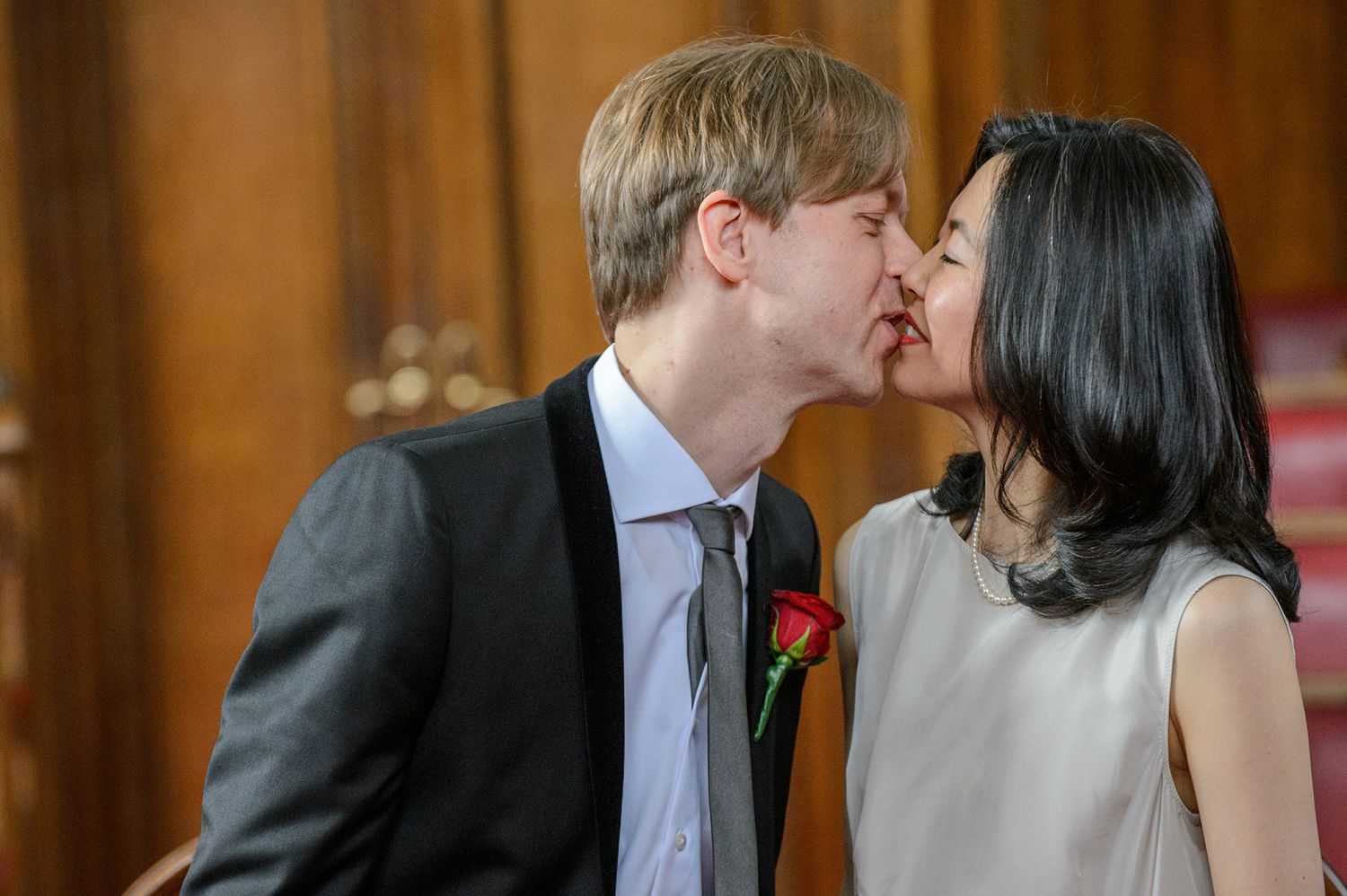 Black and white photo showing tender moments at an indoor wedding ceremony.