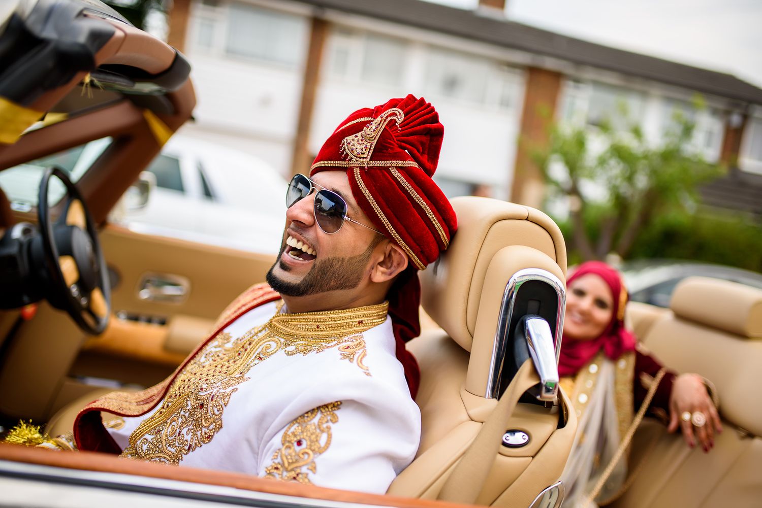 Guests celebrate at a festive South Asian wedding celebration with red and gold decorations.