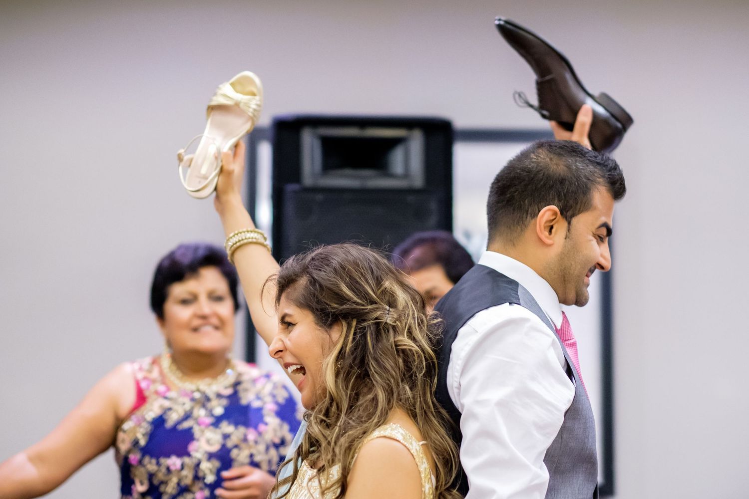 Wedding reception guests dancing and celebrating together at an indoor venue.