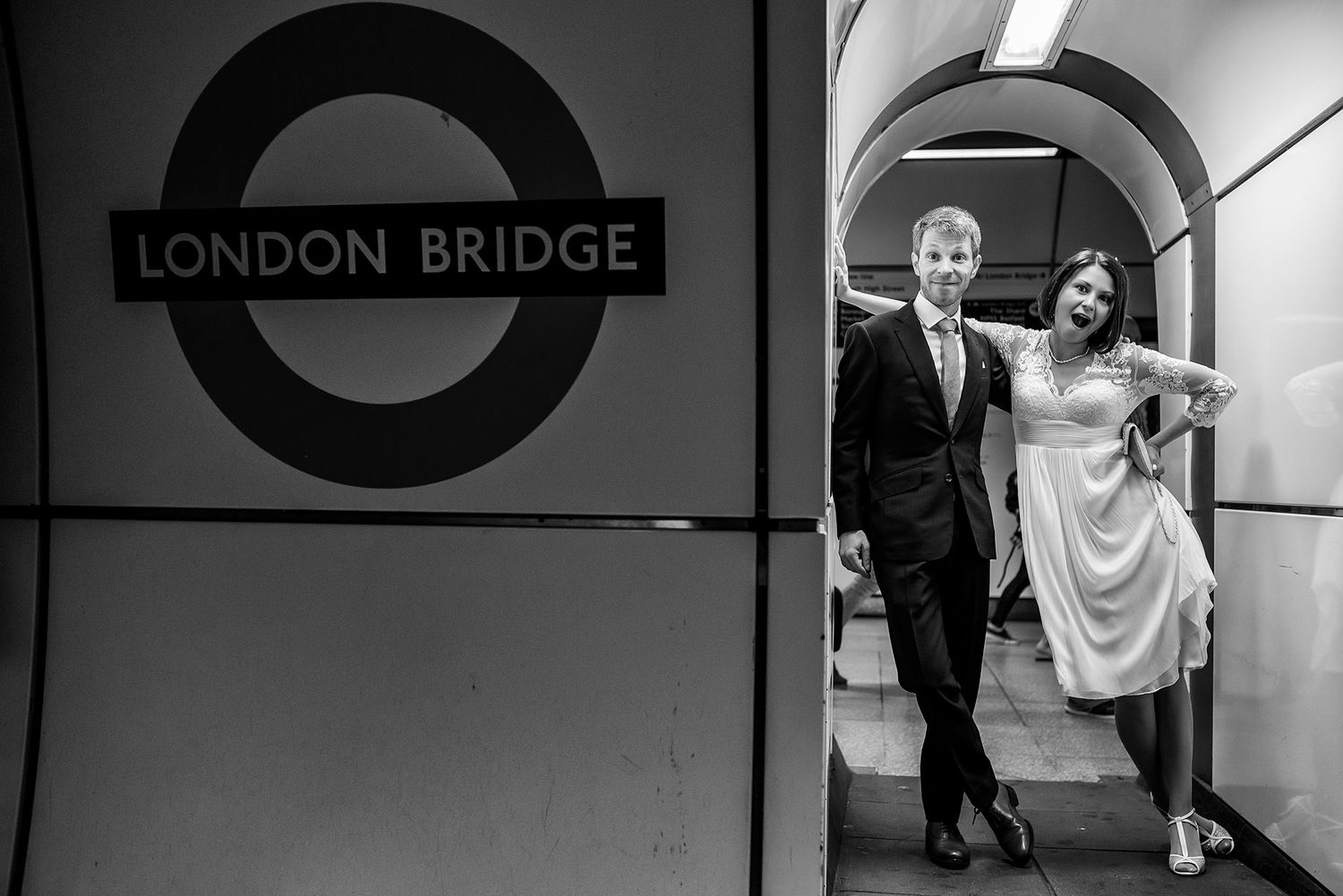 Black and white shot of London Underground station with classic tiled walls and signage.
