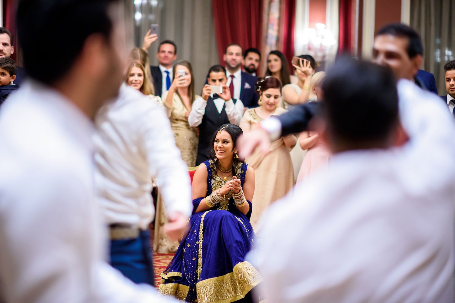 Wedding celebration with guests in formal attire mingling in an elegant ballroom setting.