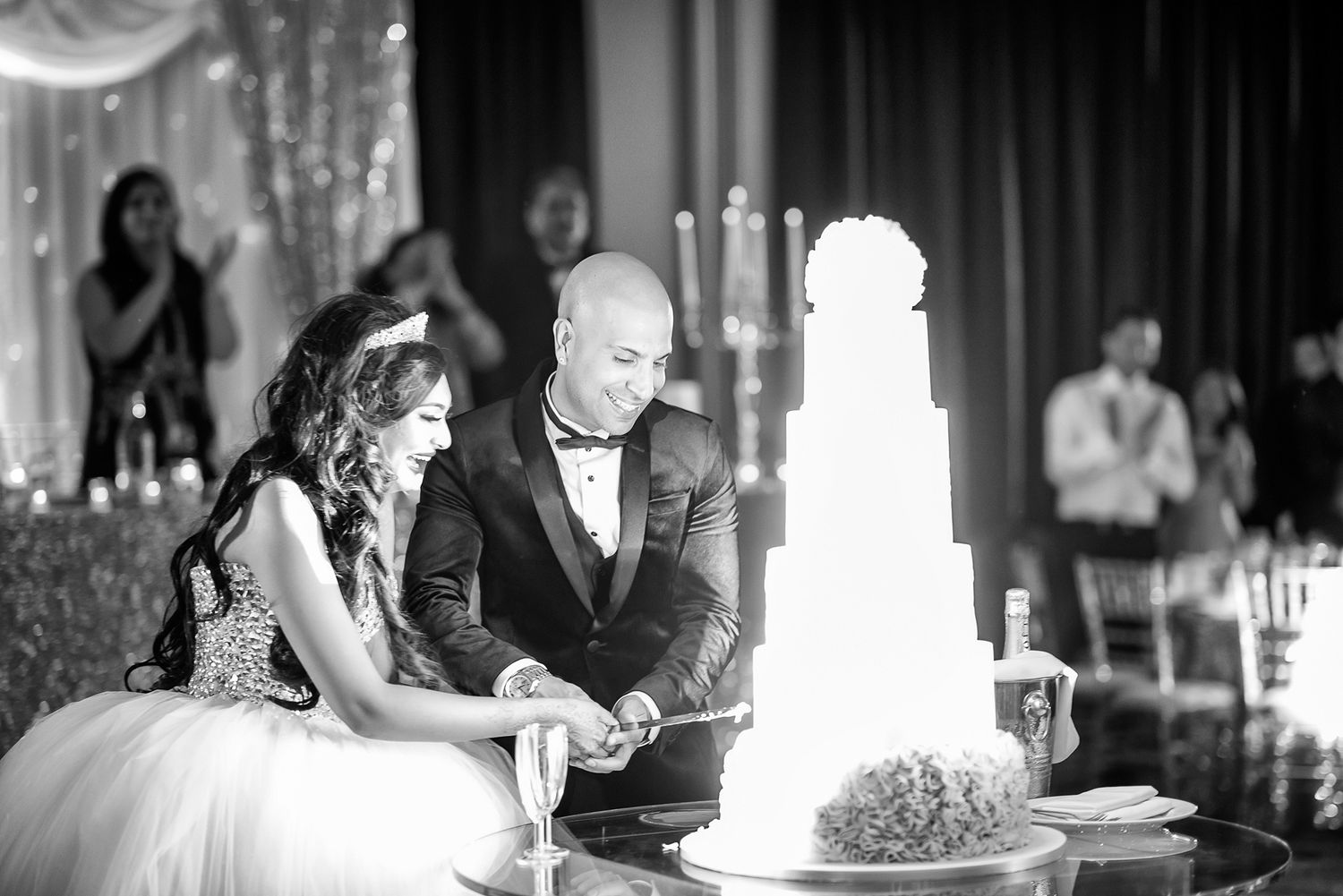 Reception venue decorated with elegant white wedding cake and hanging crystal decorations.