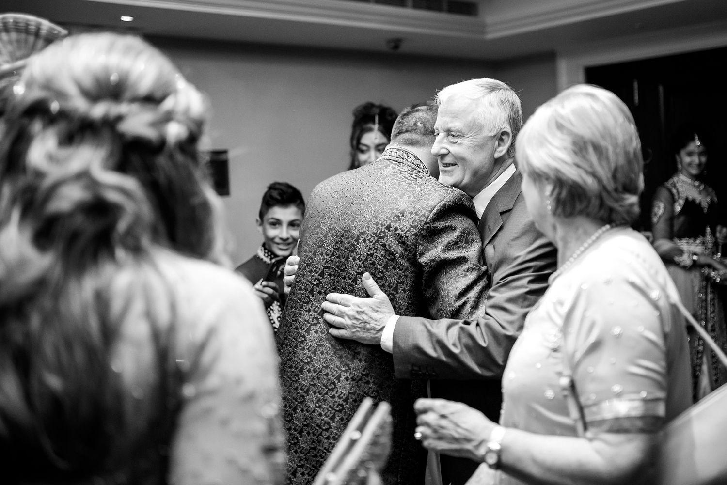 Black and white photo of guests mingling during a wedding reception.