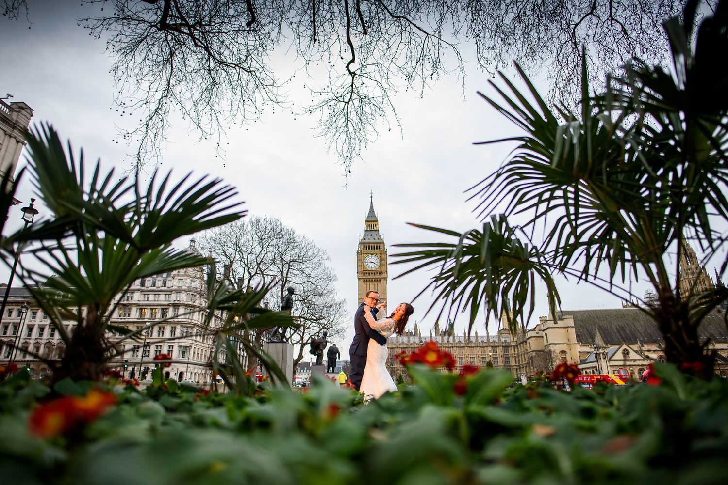 London skyline wedding photo with Big Ben visible through tropical foliage.