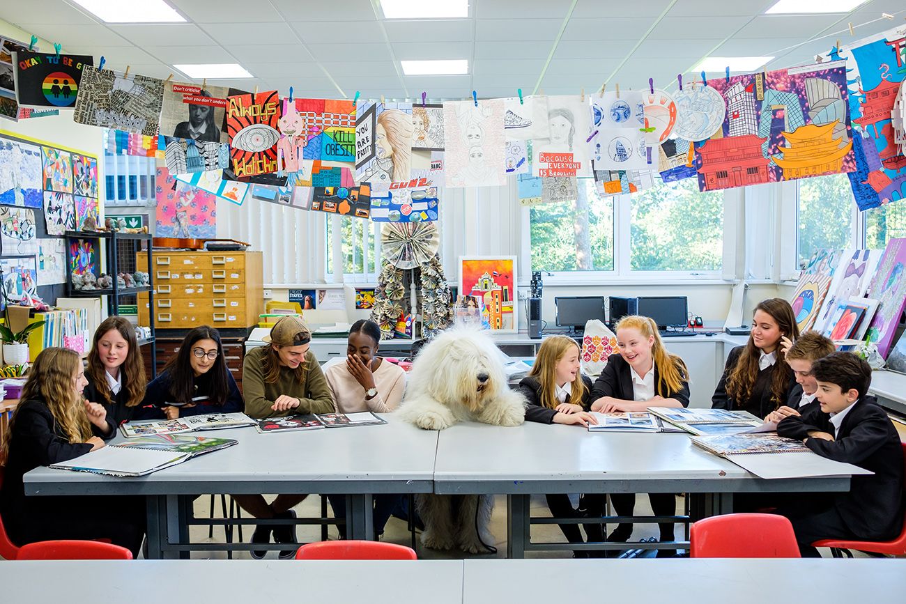 Wide classroom setting with colorful posters and student work displayed on walls.