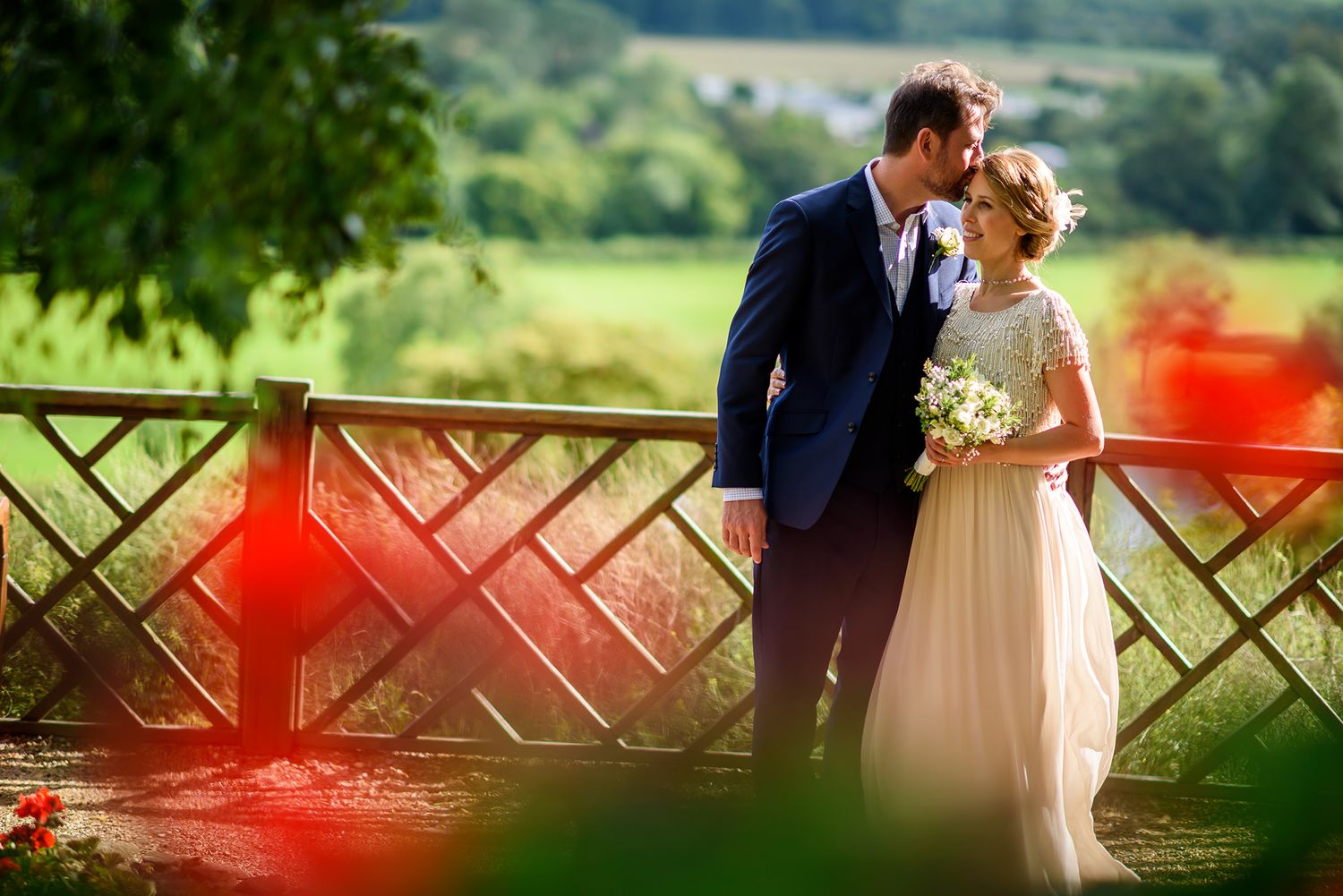 Romantic garden wedding portraits with couple against wooden lattice background.
