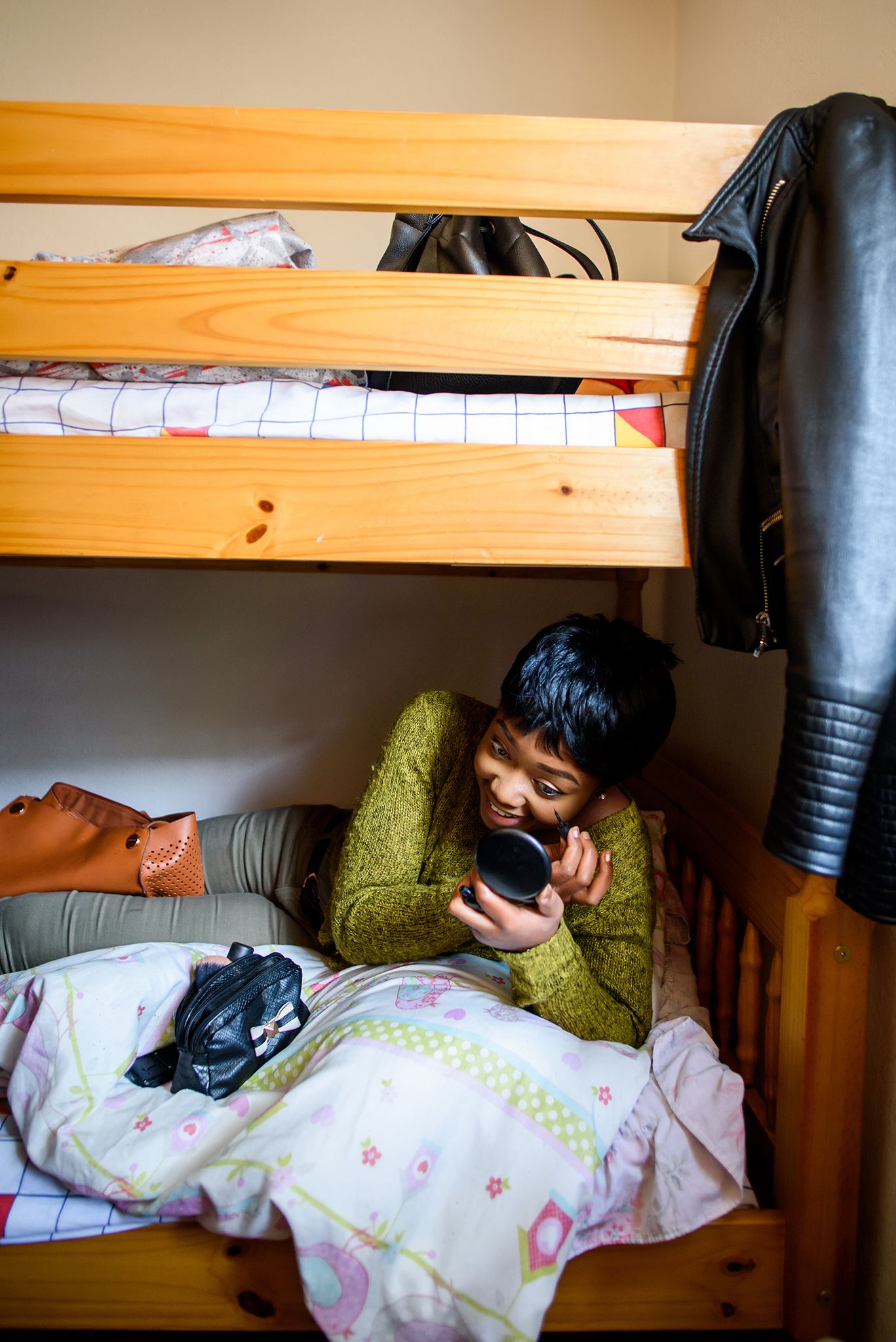 Person sleeping peacefully under floral blankets in a cozy bunk bed setting.